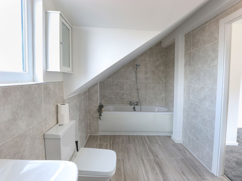 A bathroom with a bathtub and toilet at 5 Woodland Crescent in Manchester