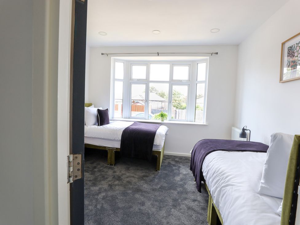 A bedroom with two beds and a window at 5 Woodland Crescent in Manchester