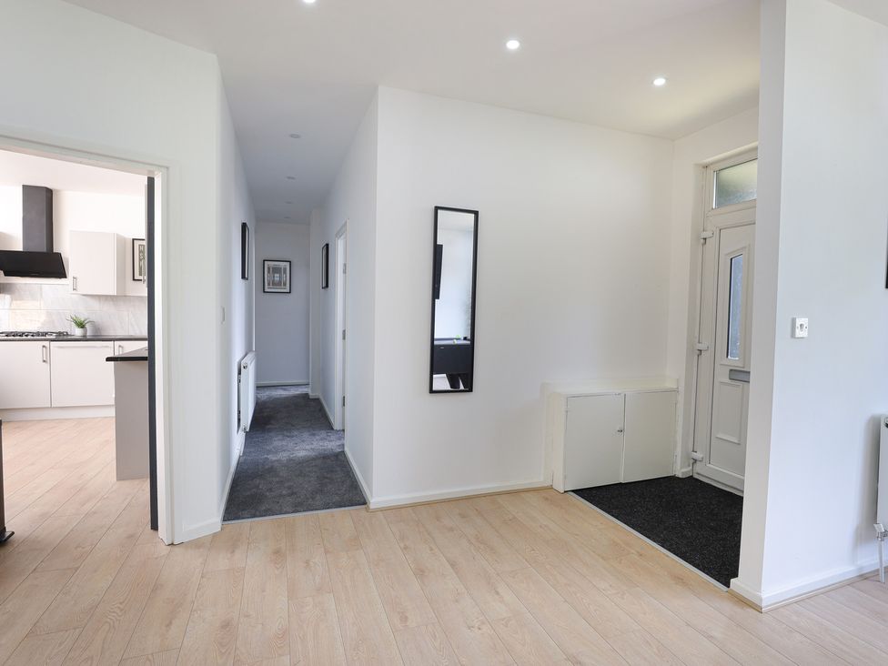 A hallway with a mirror and cabinet at 5 Woodland Crescent in Manchester