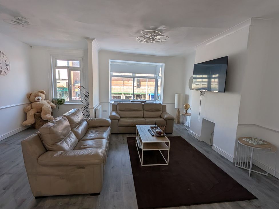 A living room with a television and a sofa at Spacious Duplex Flat in Thornton-Cleveleys