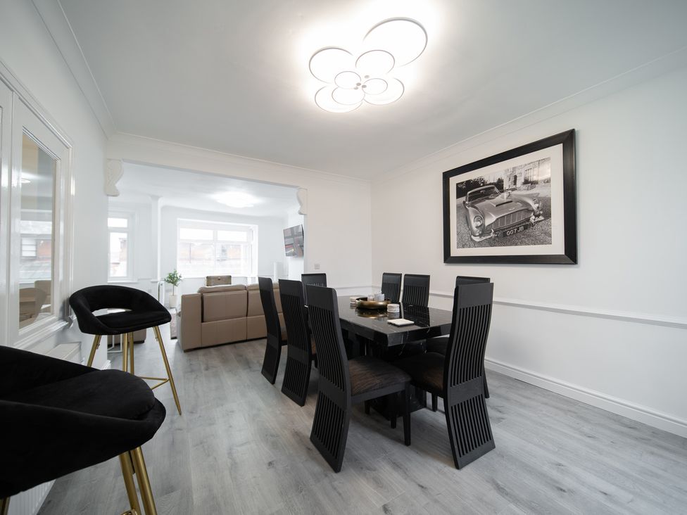 A dining room with a black dining table and chairs at Spacious Duplex Flat in Thornton-Cleveleys