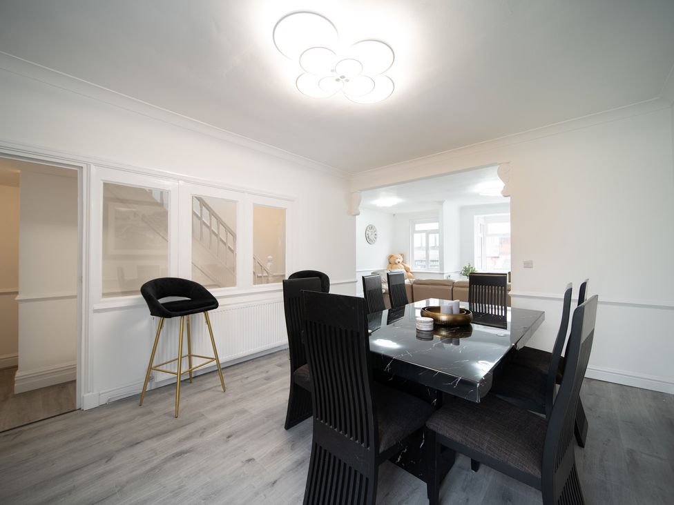 A dining room with a table and chairs at Spacious Duplex Flat in Thornton-Cleveleys