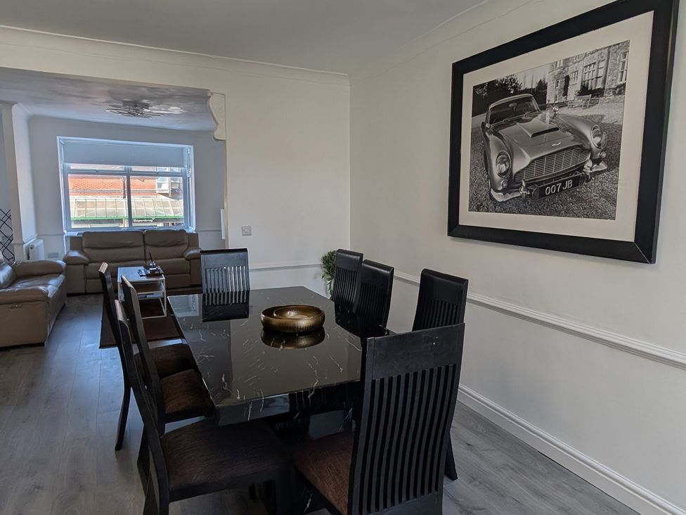 A dining area with a table and chairs at Spacious Duplex Flat in Thornton-Cleveleys
