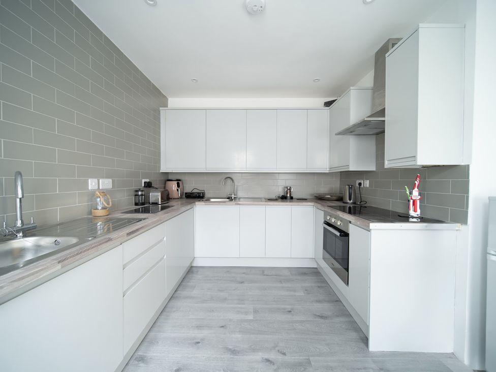 A kitchen with cabinets and appliances at Spacious Duplex Flat in Thornton-Cleveleys