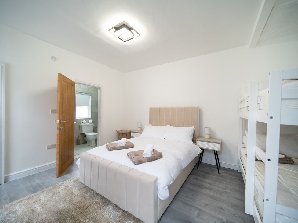 A bedroom with a double bed and a bunk bed at Spacious Duplex Flat in Thornton-Cleveleys
