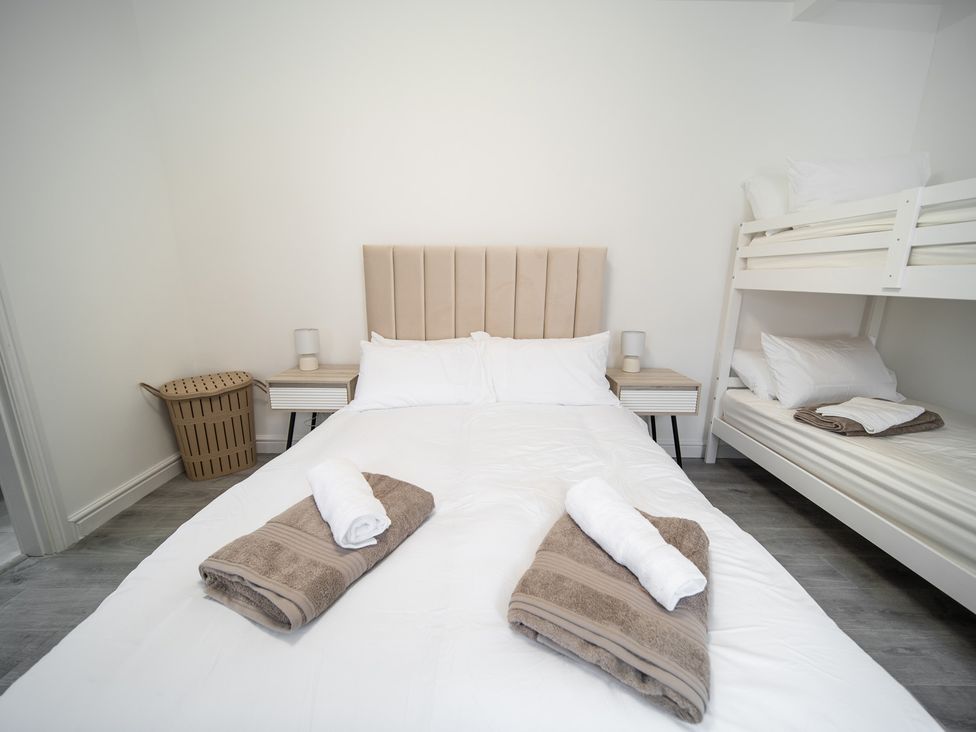 A bedroom with a bed and bunk bed at Spacious Duplex Flat in Thornton-Cleveleys