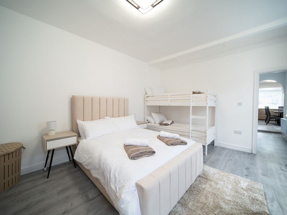 A bedroom with a double bed and bunk bed at Spacious Duplex Flat in Thornton-Cleveleys