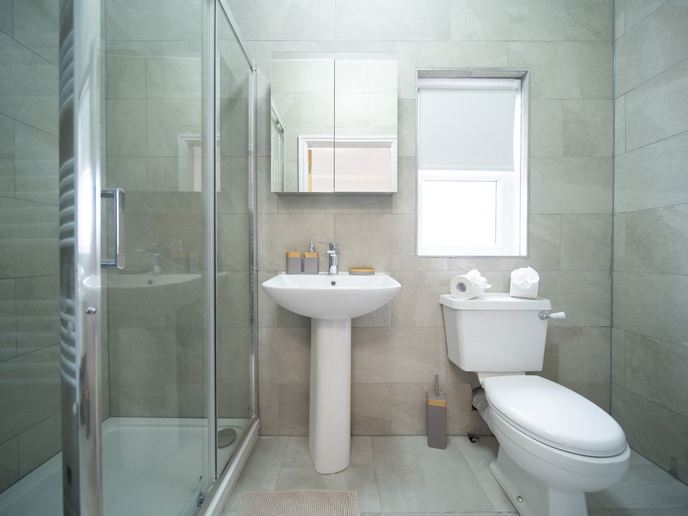 A bathroom with a shower, sink, and toilet at Spacious Duplex Flat in Thornton-Cleveleys