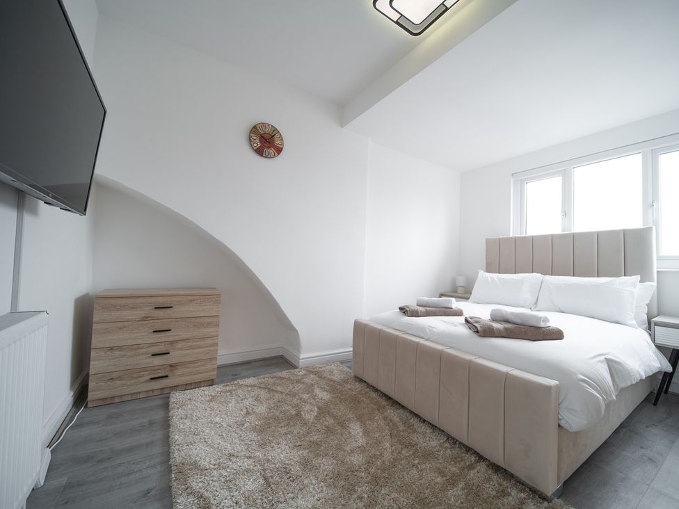 A bedroom with a bed and television at Spacious Duplex Flat in Thornton-Cleveleys