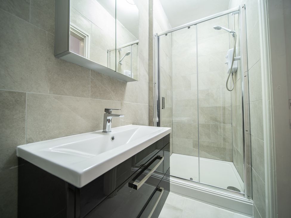 A bathroom with a shower and a vanity unit at Spacious Duplex Flat in Thornton-Cleveleys