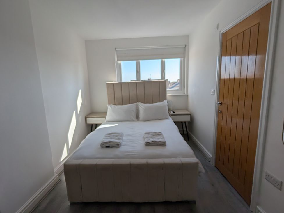 A bedroom with a bed and bedside table at Spacious Duplex Flat in Thornton-Cleveleys
