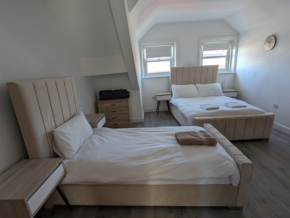 A bedroom with two beds and a nightstand at Spacious Duplex Flat in Thornton-Cleveleys