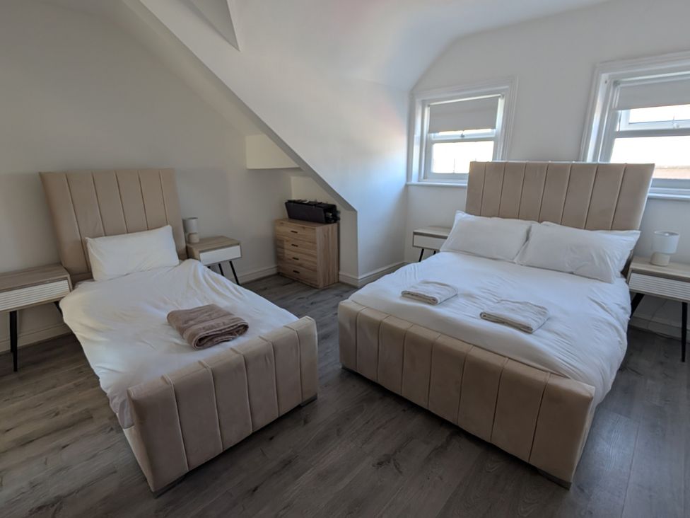 A bedroom with two beds and a dresser at Spacious Duplex Flat in Thornton-Cleveleys