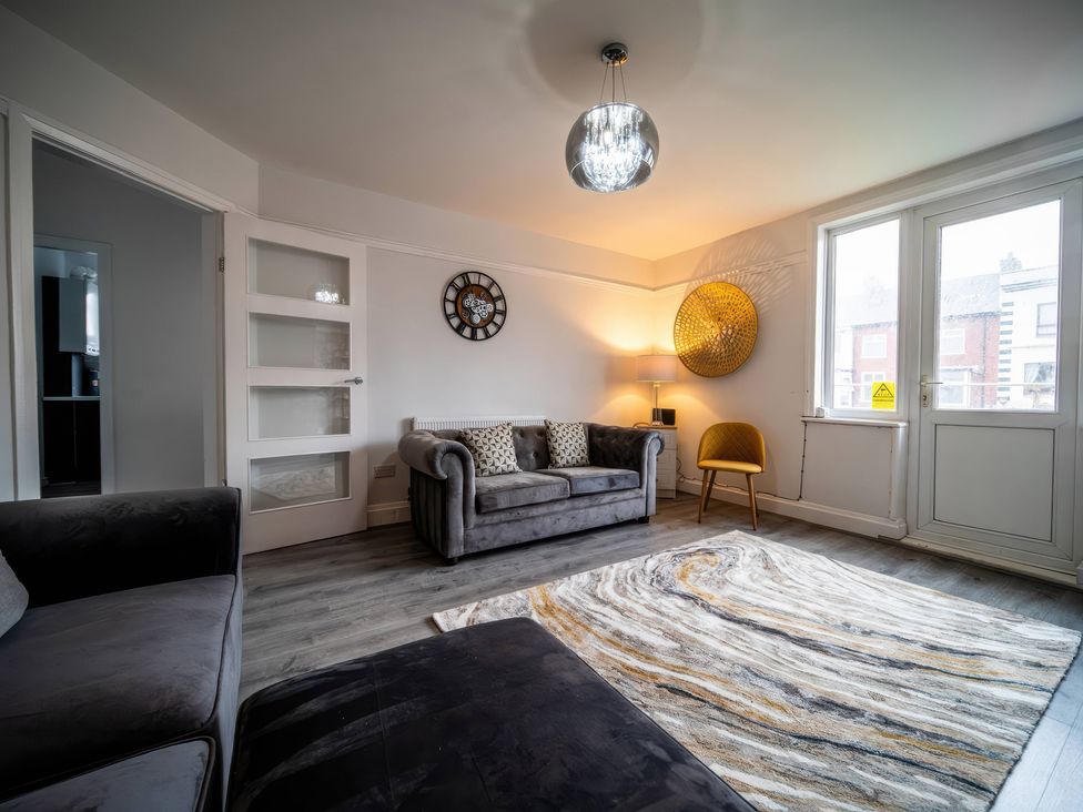 A living room with a sofa, lamp, and rug at Flat with Terrace Style Rooftop in Thornton-Cleveleys