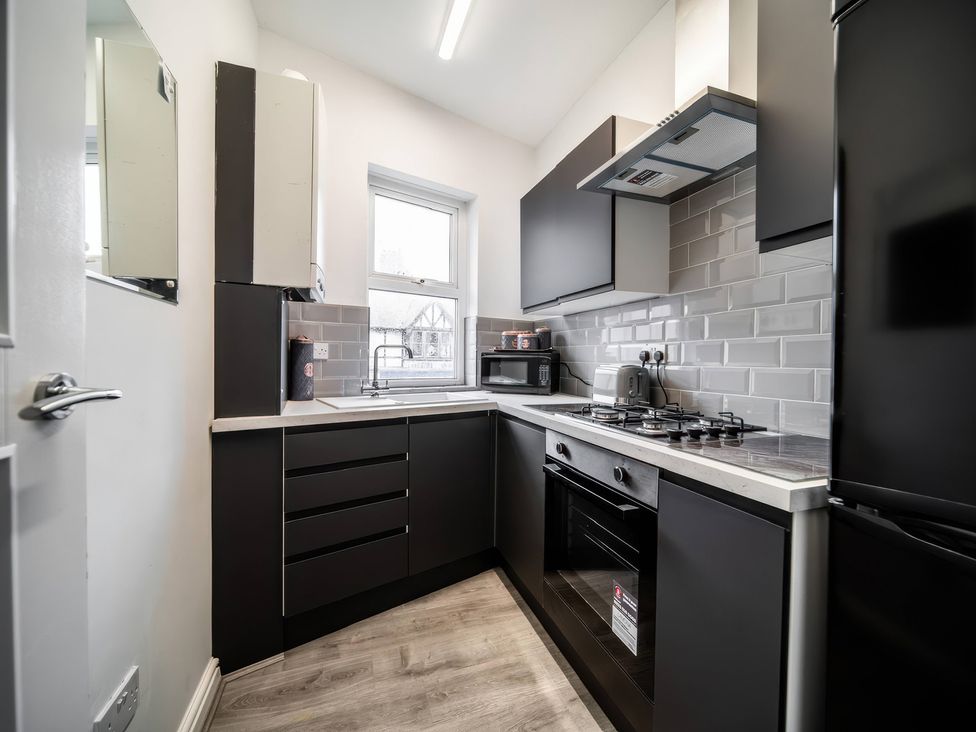 A kitchen with cabinets, sink, microwave, and stove at Flat with Terrace Style Rooftop in Thornton-Cleveleys