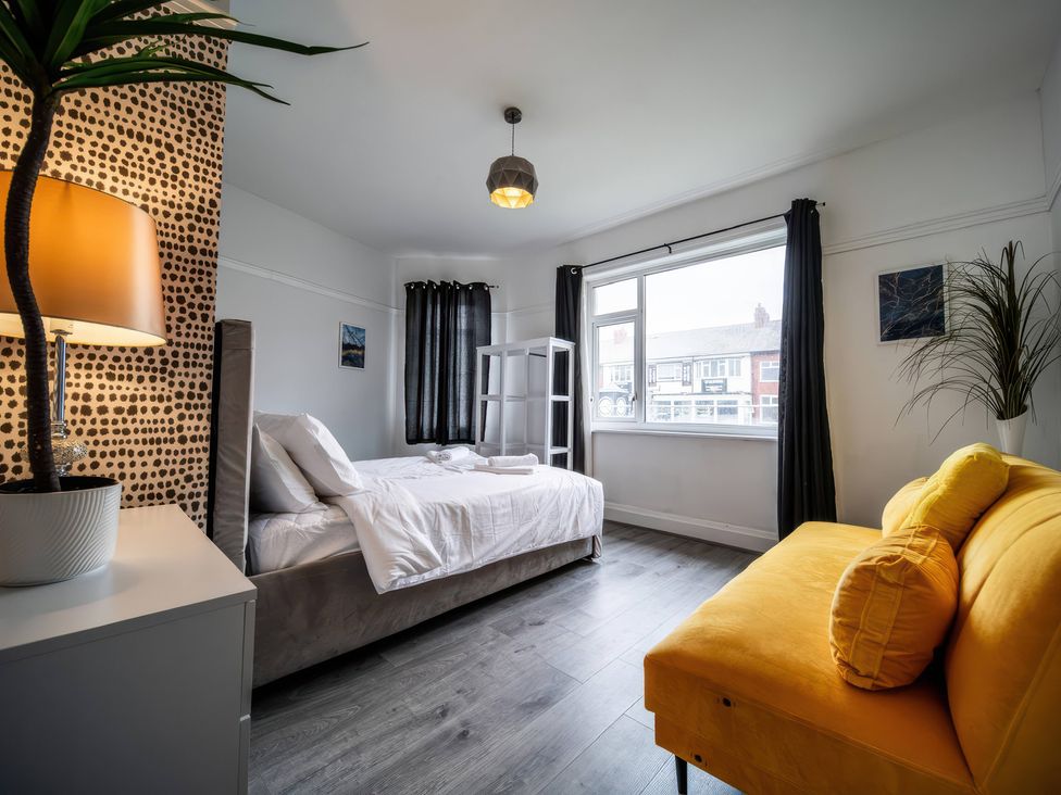 A bedroom with a bed and a sofa at Flat with Terrace Style Rooftop in Thornton-Cleveleys