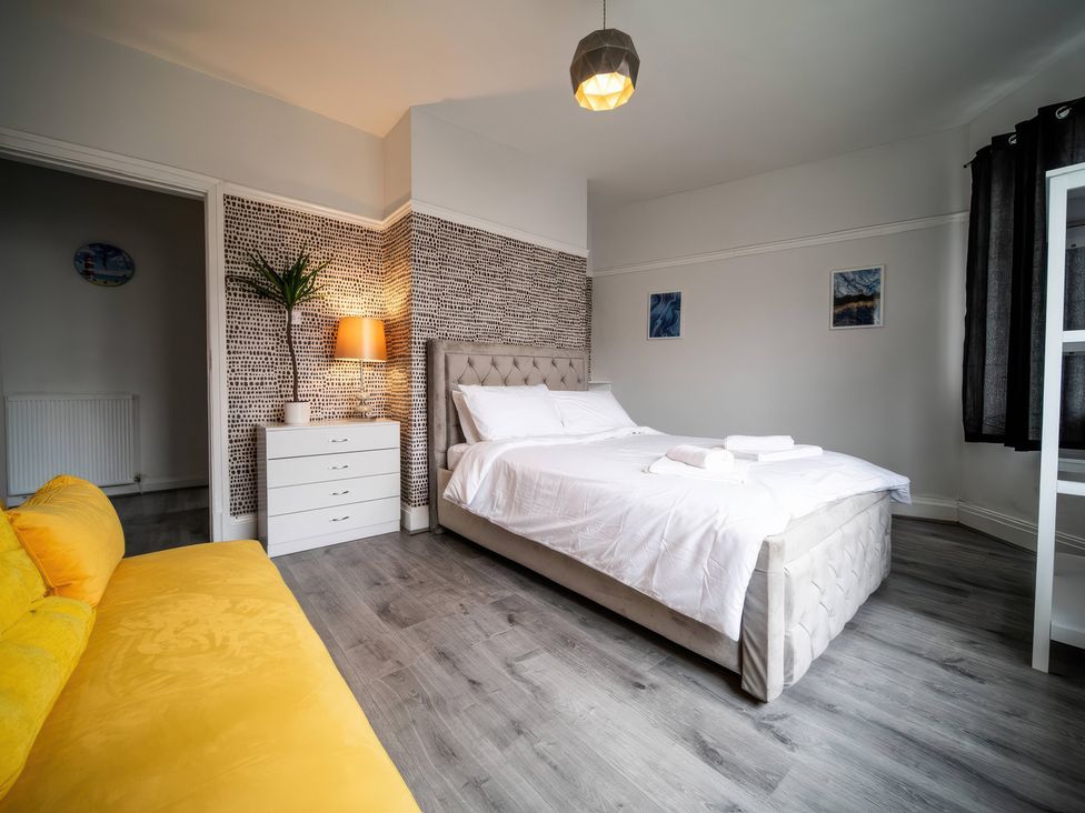 A bedroom with a bed and sofa at Flat with Terrace Style Rooftop in Thornton-Cleveleys