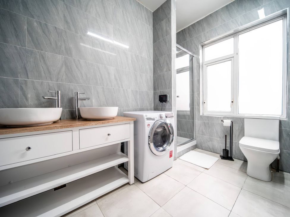 A bathroom with a washing machine and sink at Flat with Terrace Style Rooftop in Thornton-Cleveleys
