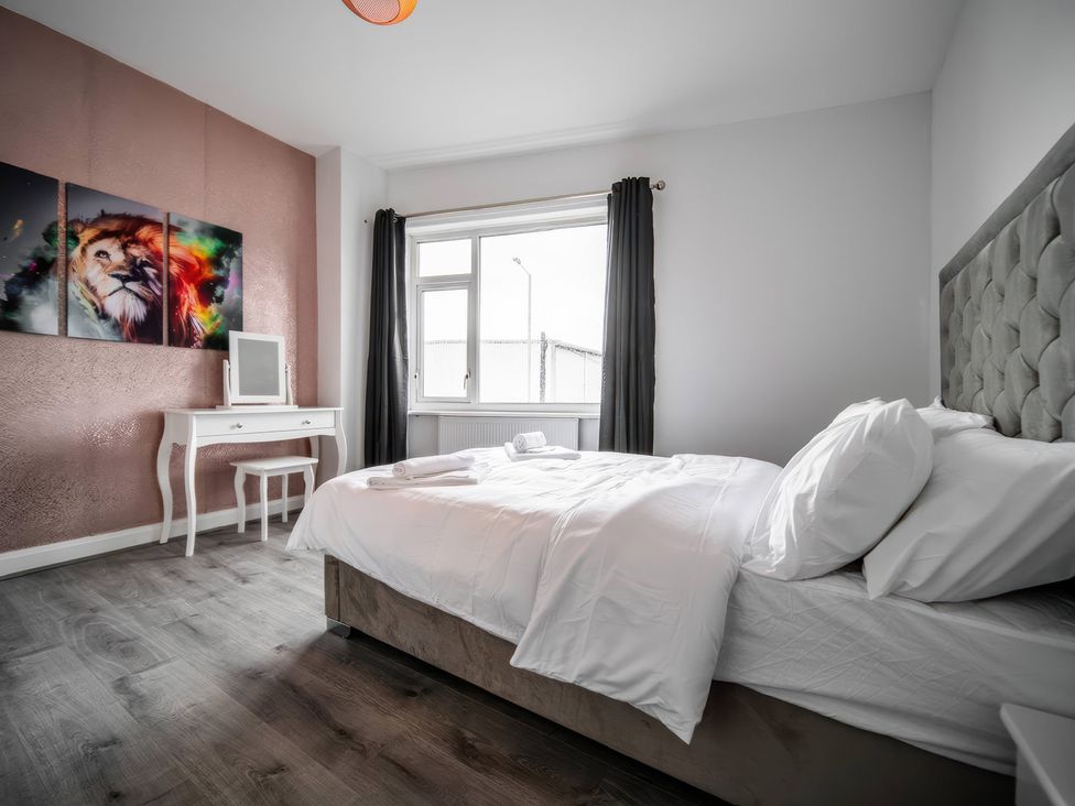 A bedroom with a bed and a window at Flat with Terrace Style Rooftop in Thornton-Cleveleys