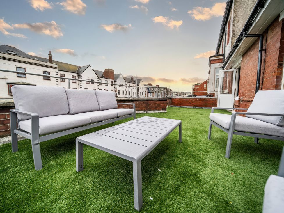 A balcony with a sofa and table at Flat with Terrace Style Rooftop in Thornton-Cleveleys