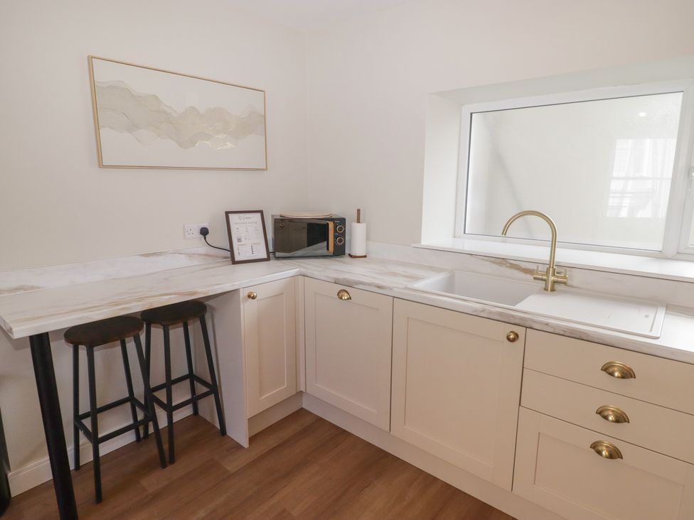 A kitchen with a sink and microwave at Flat 3 in Tenby