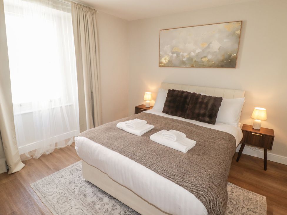 A bedroom with a bed and bedside tables at Flat 3 in Tenby