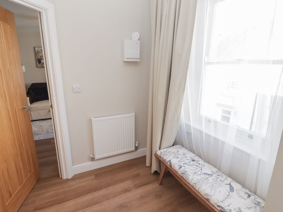 A hallway with a bench and a radiator at Flat 3 in Tenby