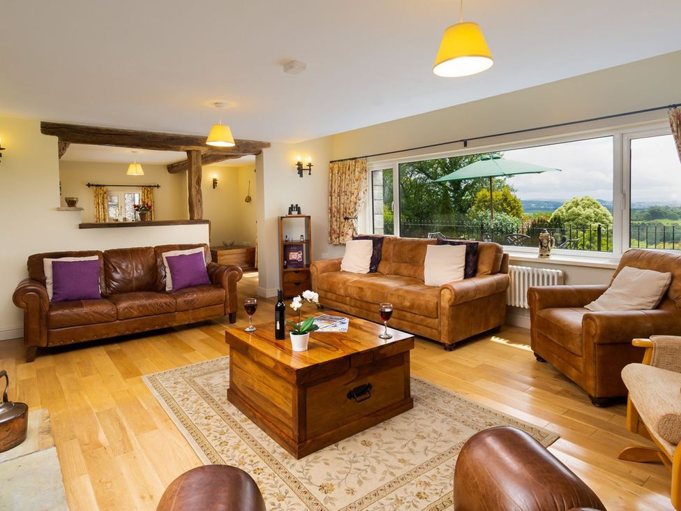 A living room with a coffee table and sofas at High Beck in Kendal