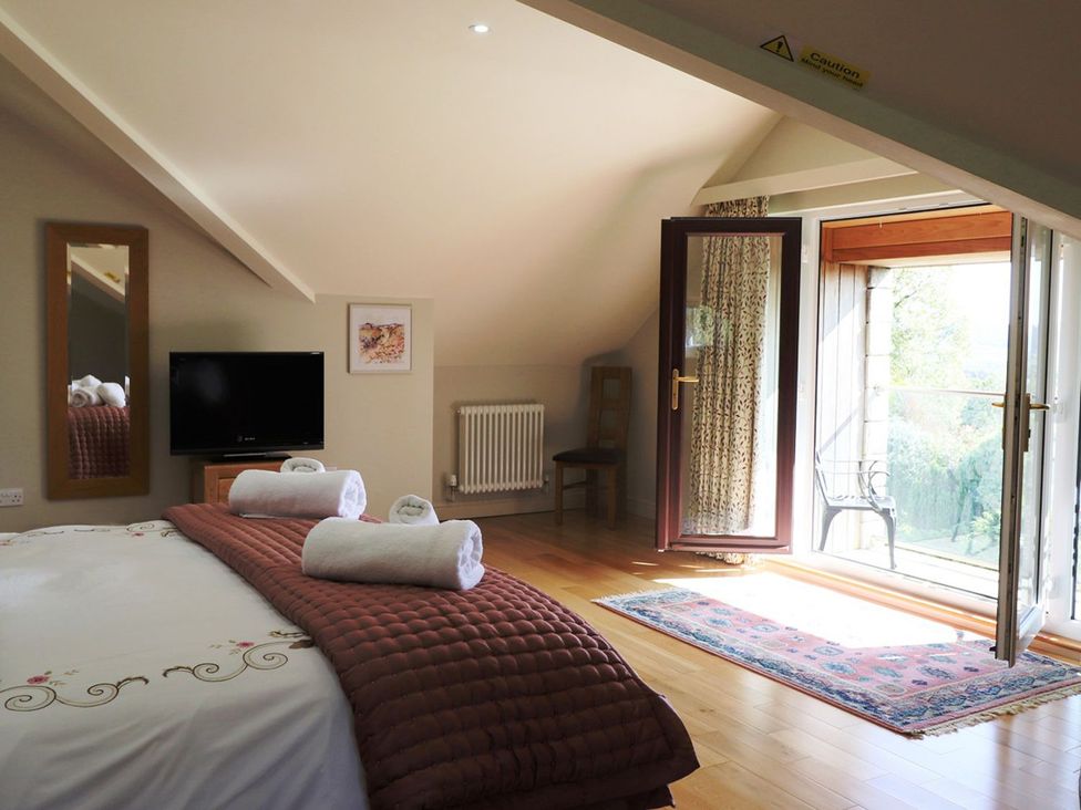 A bedroom with a bed and television at High Beck in Kendal