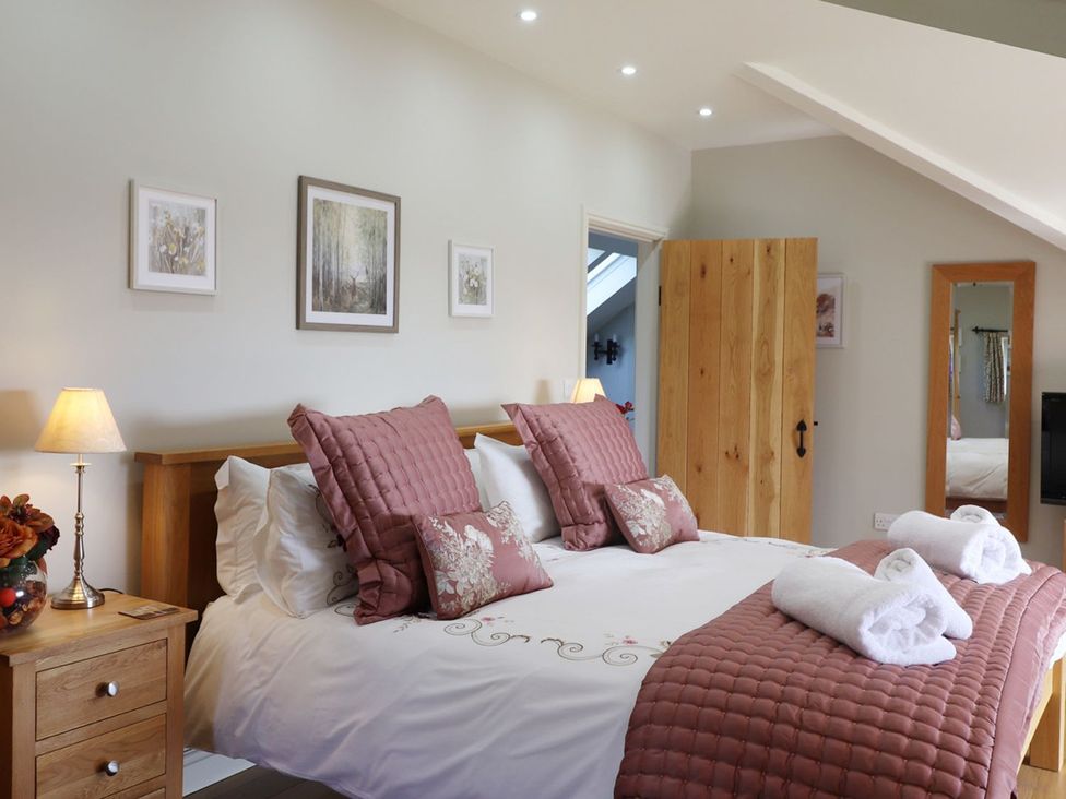 A bedroom with a bed and nightstand at High Beck in Kendal