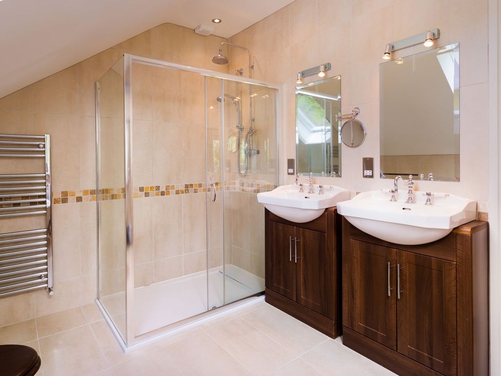 A bathroom with double sinks and a shower at High Beck in Kendal