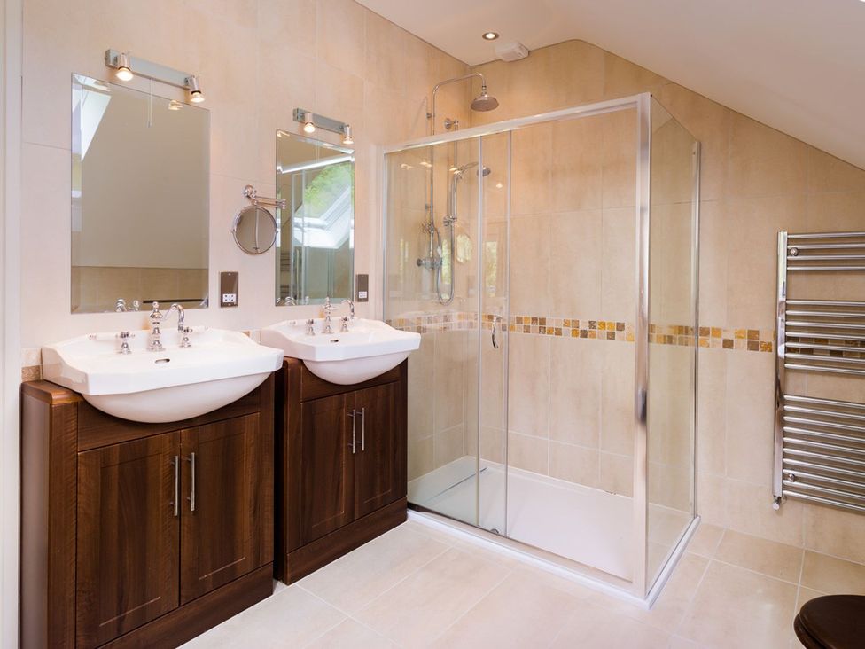 A bathroom with two sinks and a shower at High Beck Kendal