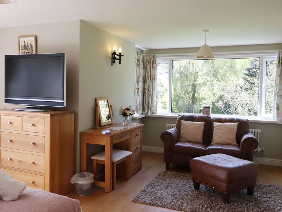 A living room with a television and a sofa at High Beck in Kendal