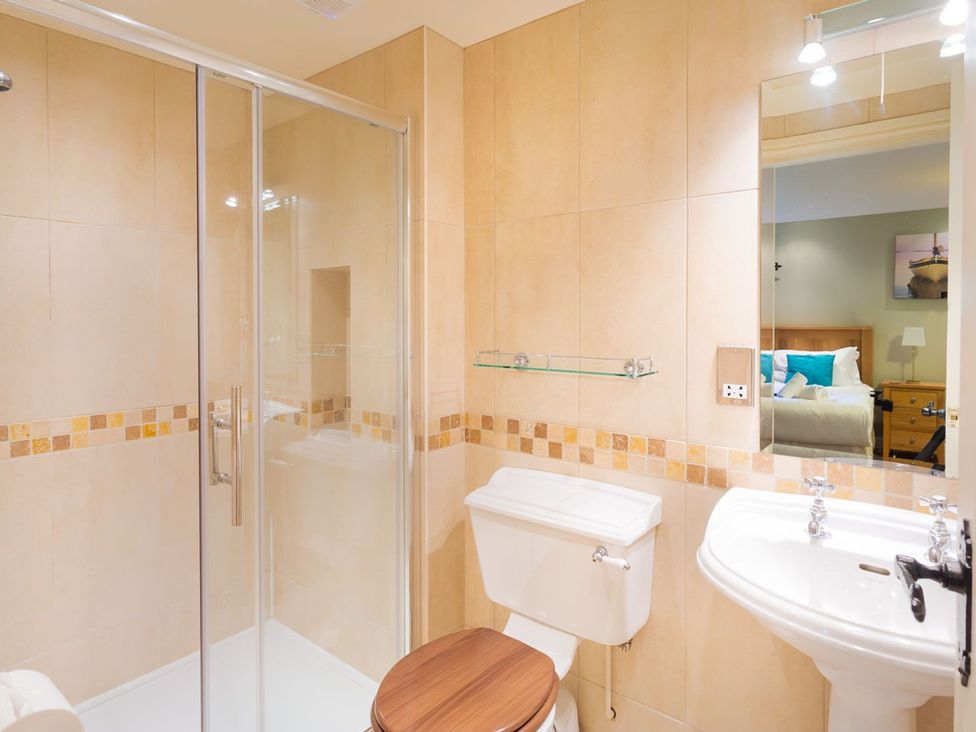 A bathroom with a shower, toilet, and sink at High Beck in Kendal