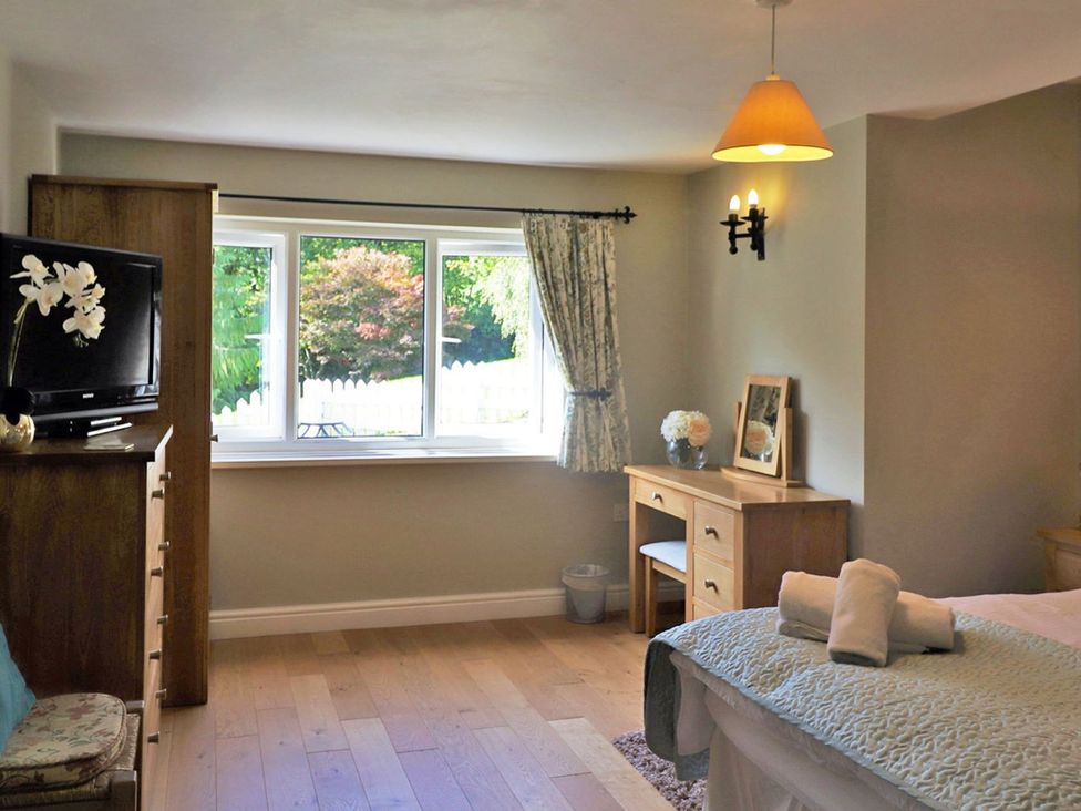 A bedroom with a window and dresser at High Beck in Kendal