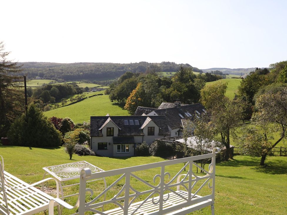 A house with trees and a grassy area at High Beck in Kendal