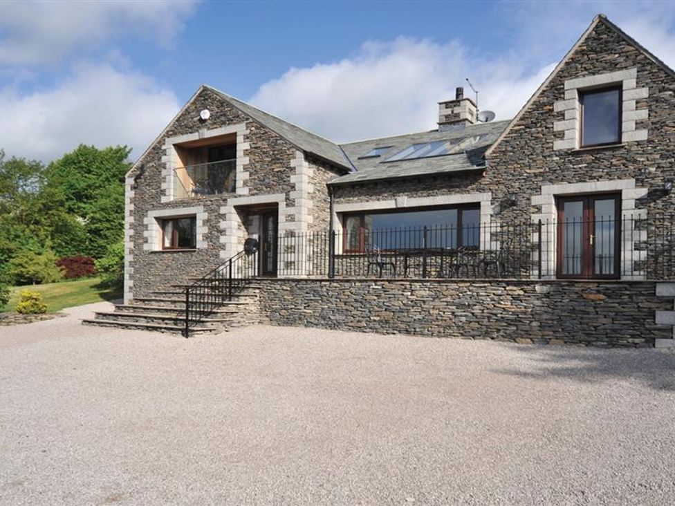 A stone house with a balcony and steps at High Beck in Kendal