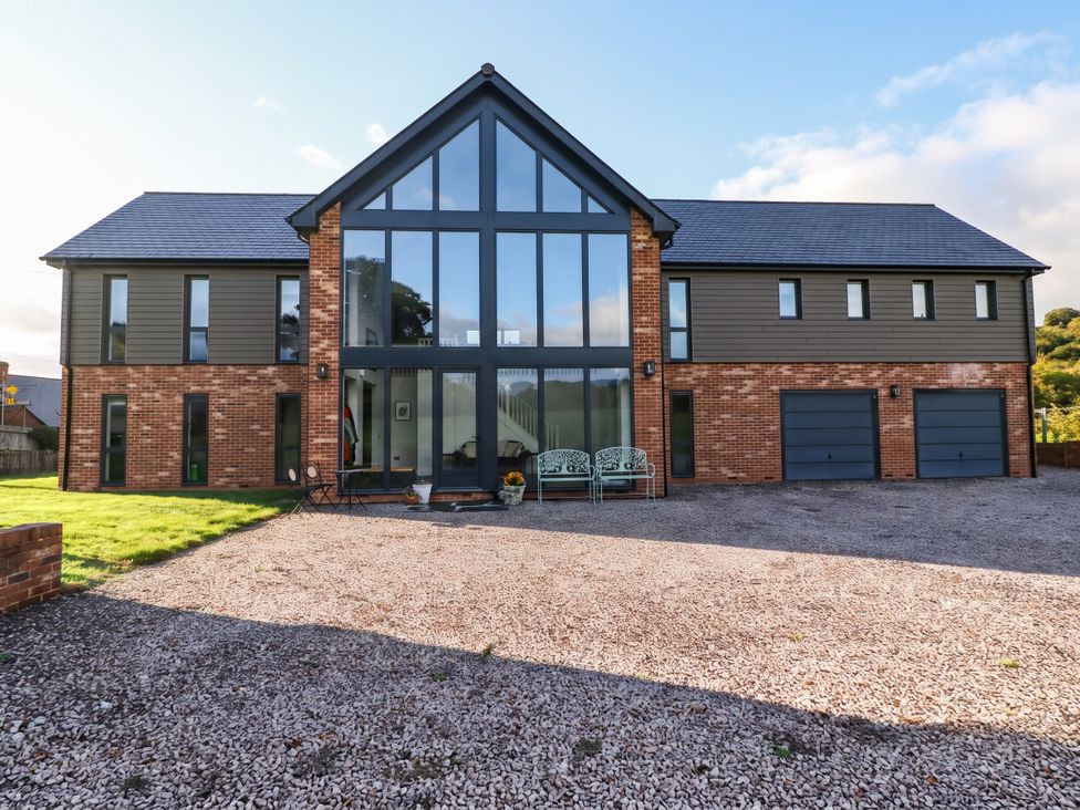 A modern house with large windows and garages at Hanbury House Lea