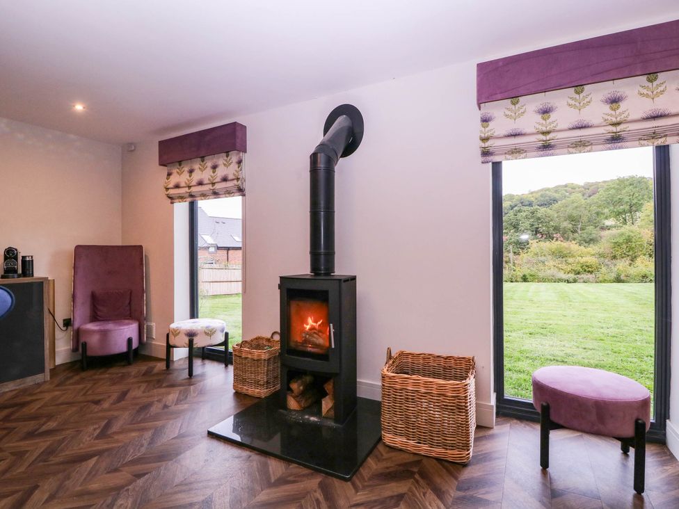 A living room with a stove and seating at Hanbury House in Lea