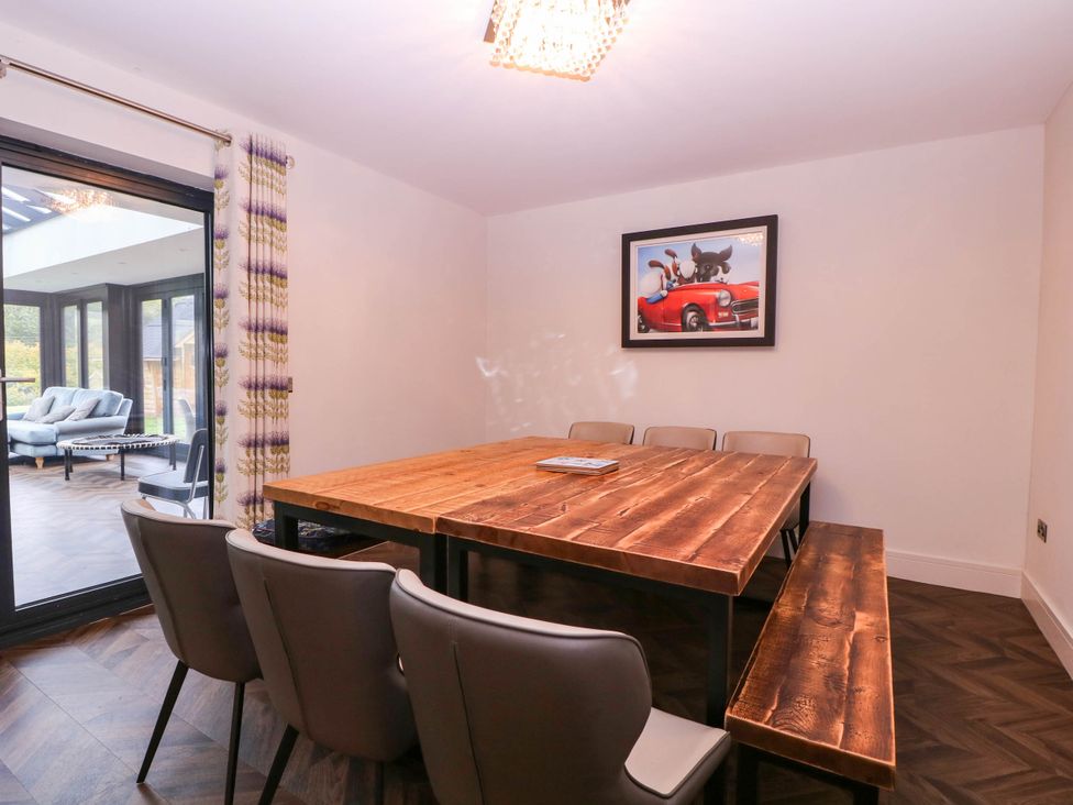 A dining room with a wooden table and chairs at Hanbury House in Lea