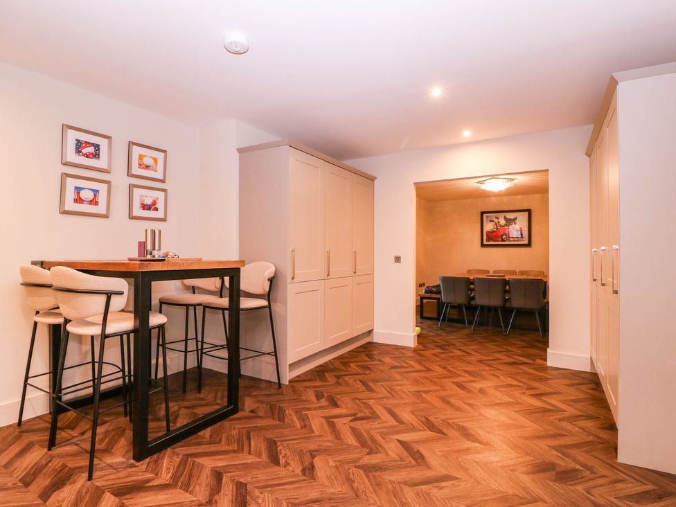 A dining room with a bar table and stools at Hanbury House Lea