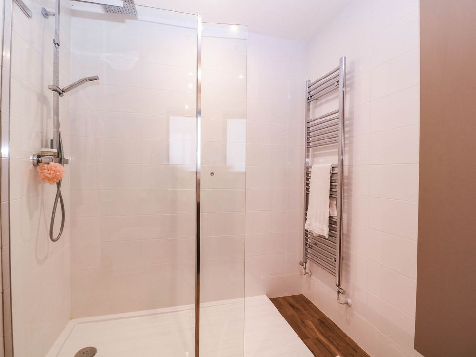 A bathroom with a glass shower and towel rack at Hanbury House Lea