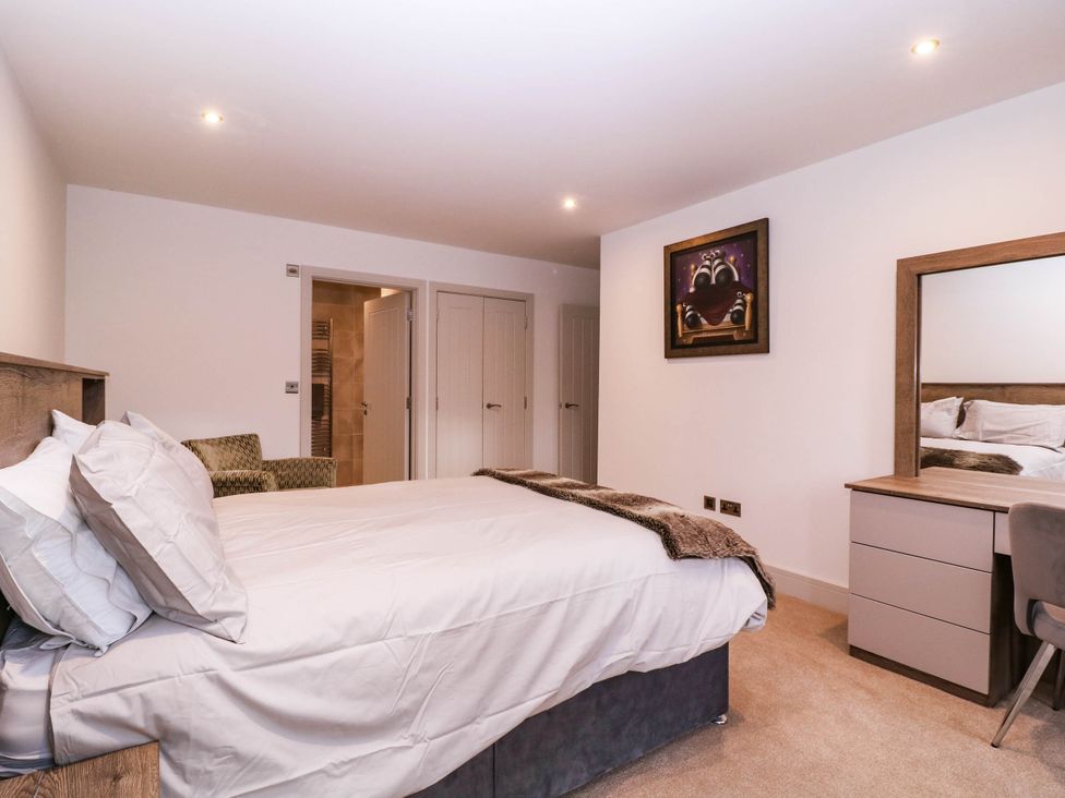 A bedroom with a bed and mirror at Hanbury House in Lea