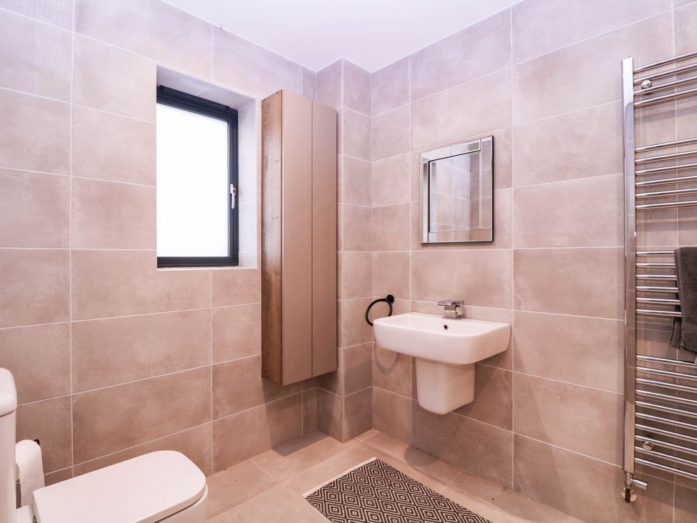 A bathroom with a toilet, sink, and towel rack at Hanbury House in Lea