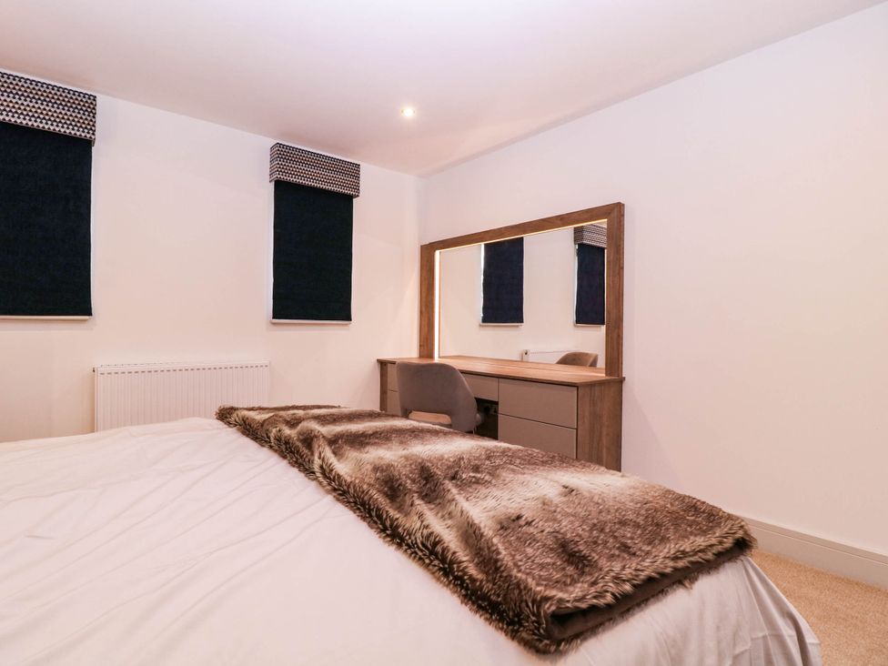 A bedroom with a bed and dressing table at Hanbury House Lea