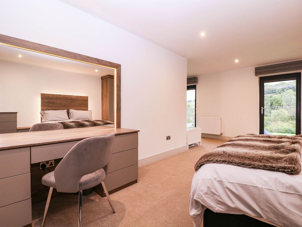 A bedroom with a bed, desk, and window at Hanbury House, Lea