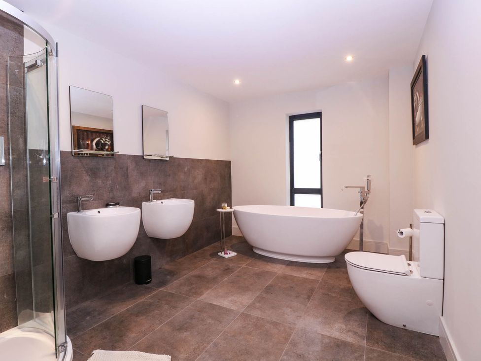 A bathroom with a bathtub, shower, sink, and toilet at Hanbury House in Lea