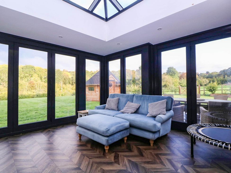 A conservatory with a sofa and coffee table at Hanbury House in Lea