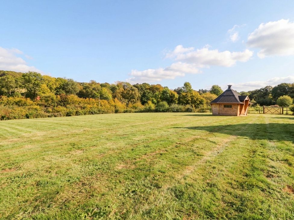 An outdoor area with grass and a wooden building at Hanbury House in Lea