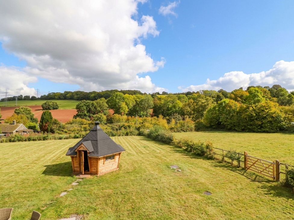 A cabin in a field surrounded by trees at Hanbury House in Lea